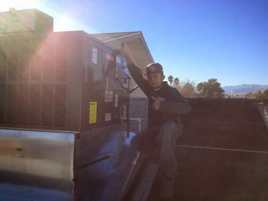 HVAC technician performing AC Tune-Up on a rooftop unit in Berkley